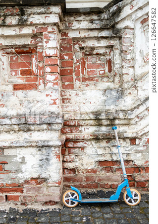 blue scooter near brick shabby monastery wall blue scooter near brick shabby monastery wall 126647582