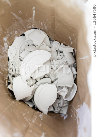 fragments of unfired porcelain in cardboard box 126647590