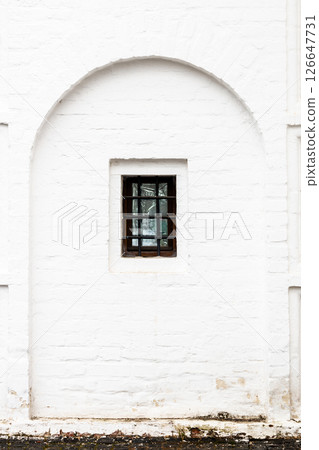 barred window in old white monastery wall barred window in old white monastery wall 126647731