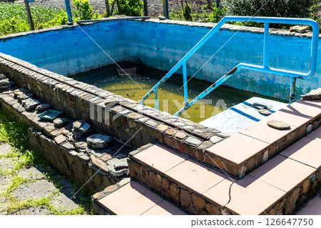 old abandoned swimming pool with water remains old abandoned swimming pool with water remains 126647750