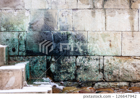 lichen covered stone wall and steps in monastery 126647942