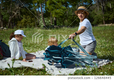 Family Enjoying a Cozy Picnic Outdoors in a Beautiful Meadow 126648445