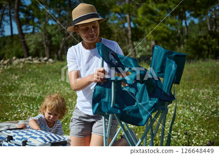 Mother and Child Enjoying a Picnic in a Scenic Forest With Greenery and Sunshine Mother and Child Enjoying a Picnic in a Scenic Forest With Greenery and Sunshine 126648449