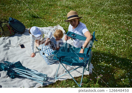 Family Enjoying a Picnic Outing on a Beautiful Sunny Day Family Enjoying a Picnic Outing on a Beautiful Sunny Day 126648450
