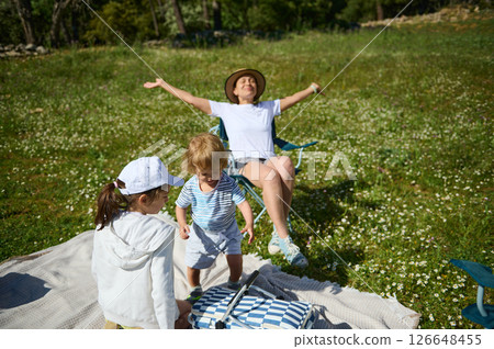 Family Enjoying a Picnic Outdoors on a Sunny Day in a Blooming Meadow 126648455