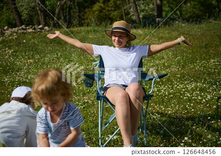 Woman Enjoying Outdoor Gathering With Family Celebrating National Eat Outside Day Woman Enjoying Outdoor Gathering With Family Celebrating National Eat Outside Day 126648456