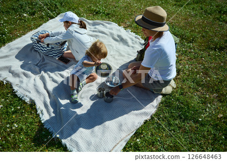 Family Enjoying a Picnic Outdoors Embracing Togetherness and Nature Family Enjoying a Picnic Outdoors Embracing Togetherness and Nature 126648463