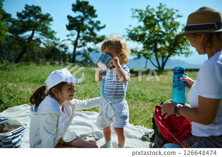 Family Bonding During a Sunny Outdoor Picnic Amidst Scenic Mountain Views Family Bonding During a Sunny Outdoor Picnic Amidst Scenic Mountain Views 126648474