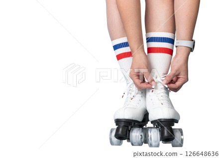 Young female tying laces on white roller skates with red and blue striped socks 126648636