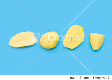 Raw peeled potatoes on blue background 126649021