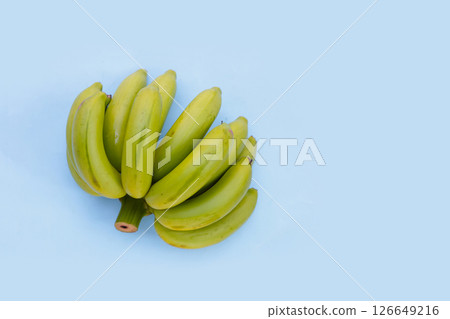 Green banana on blue background. 126649216