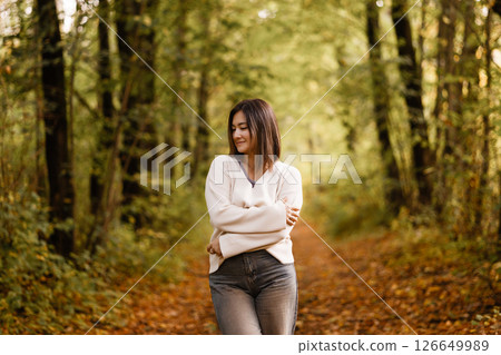 Young Woman Smiling in Autumn Forest Path 126649989