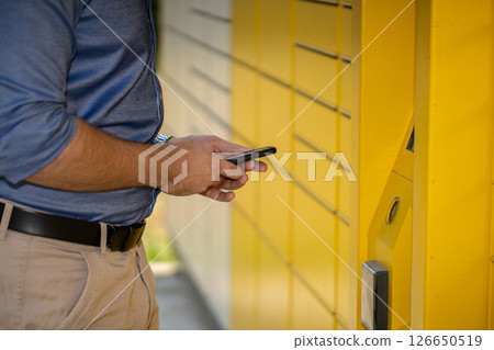 Unlocking the Convenience of User Accessing a Modern Package Locker for Easy Delivery Services 126650519