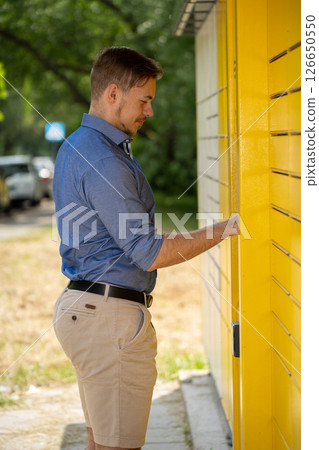 A man thoughtfully interacting with a vibrant and vivid yellow wall, creating a striking scene 126650550