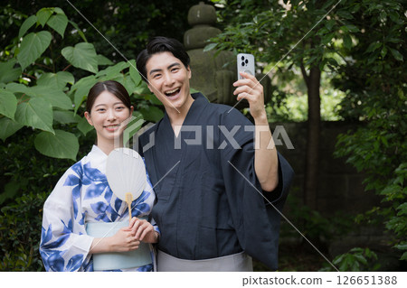 Couple in yukata taking a selfie with a smartphone, image of sightseeing and travel, looking at the camera Couple in yukata taking a selfie with a smartphone, image of sightseeing and travel, looking at the camera 126651388