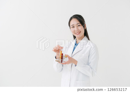 A woman in a white coat doing research 126653217