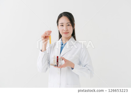 A woman in a white coat doing research A woman in a white coat doing research 126653223