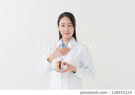 A woman in a white coat doing research A woman in a white coat doing research 126653224