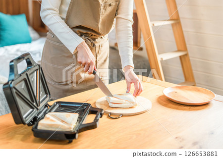 熱三明治機裡的熱三明治，女人的手在準備三明治 126653881