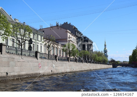 A Beautiful Scenic Riverbank Showcasing Historic Architecture and Bright Blue Skies Above A Beautiful Scenic Riverbank Showcasing Historic Architecture and Bright Blue Skies Above 126654167