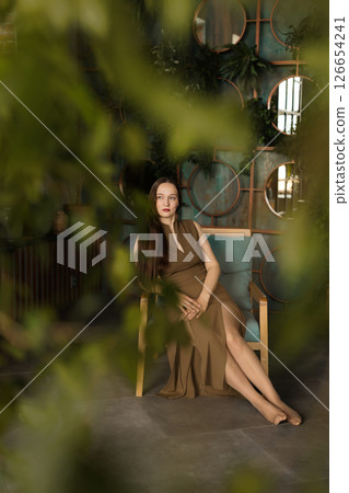 An Elegant Woman Posing in a Chic Interior Decorated with Beautiful Greenery and Plants 126654241