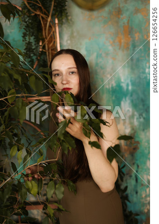 An Elegant Woman Surrounded by Lush Greenery with a Beautiful and Artistic Background An Elegant Woman Surrounded by Lush Greenery with a Beautiful and Artistic Background 126654256