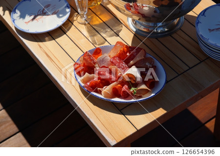 A beautifully arranged Assorted Charcuterie Platter displayed elegantly on a Wooden Table A beautifully arranged Assorted Charcuterie Platter displayed elegantly on a Wooden Table 126654396