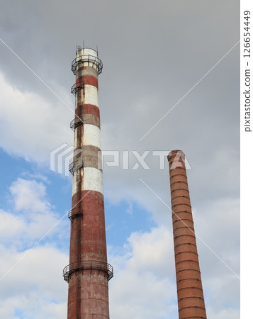 Industrial Smoke Stacks Silhouetted Against a Dramatic and Colorful Sky Background Industrial Smoke Stacks Silhouetted Against a Dramatic and Colorful Sky Background 126654449