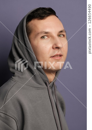Casual Portrait of a Young Man Wearing a Hoodie Set Against a Modern Urban Background Casual Portrait of a Young Man Wearing a Hoodie Set Against a Modern Urban Background 126654490