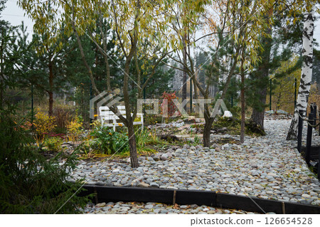 A Tranquil Autumn Garden featuring beautifully designed Pathways and comfortable Seating A Tranquil Autumn Garden featuring beautifully designed Pathways and comfortable Seating 126654528