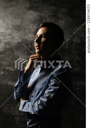A Contemplative Portrait of a Young Man Captured in Stunning and Dramatic Lighting Scenes A Contemplative Portrait of a Young Man Captured in Stunning and Dramatic Lighting Scenes 126654655