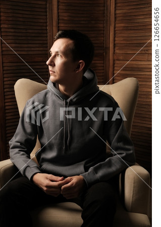 Contemplative Young Man Dressed in Casual Comfortable Attire, Appearing Calm and Chill Contemplative Young Man Dressed in Casual Comfortable Attire, Appearing Calm and Chill 126654656