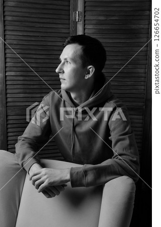 A Contemplative Portrait of a Young Man Captured in Striking Black and White Tones A Contemplative Portrait of a Young Man Captured in Striking Black and White Tones 126654702