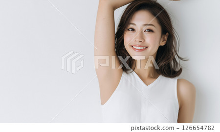 A clean beauty portrait of a smiling woman in white clothes showing her armpits (beauty, beauty, hair removal, cosmetics) 126654782
