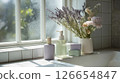 Bottles and soaps lined up by a window where natural light pours in, along with the colorful lavender and flowers (Beauty/Lifestyle) 126654847