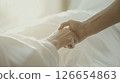 The moment when the hands of a caregiver and an elderly person join hands, creating a sense of trust and bond (caregiving and welfare) 126654863