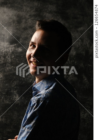A Smiling Young Boy Captured in a Portrait with Dramatic and Beautiful Lighting Effects 126654874