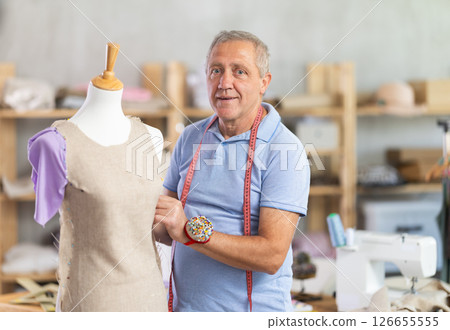 Man tailor adjusts clothes on mannequin Man tailor adjusts clothes on mannequin 126655555