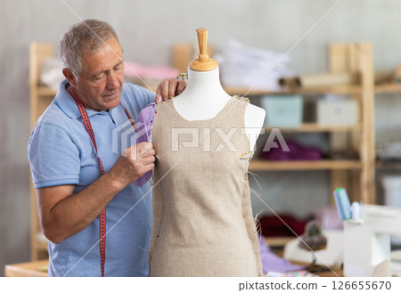 Man tailor adjusts clothes on mannequin Man tailor adjusts clothes on mannequin 126655670
