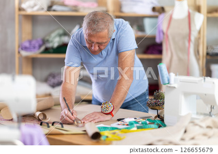 Tailor drawing on paper with pencil 126655679