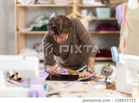 Man tailor makes pattern using tablet 126655715