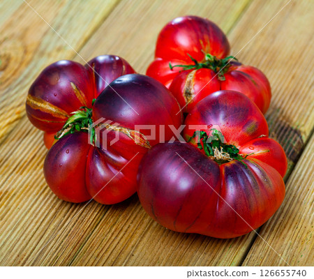 Close-up of fresh brown tomatoes on wooden surface 126655740