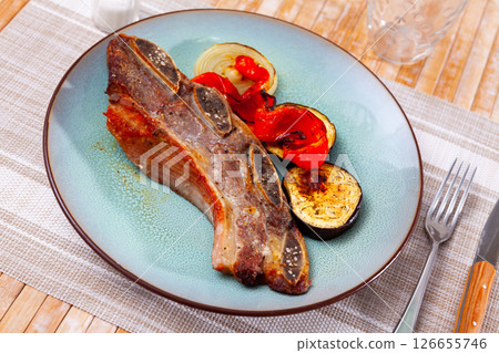 on blue plate-grilled beef ribs with fried vegetables-aubergine, pepper,onion.Spanish dish-churrasco on blue plate-grilled beef ribs with fried vegetables-aubergine, pepper,onion.Spanish dish-churrasco 126655746