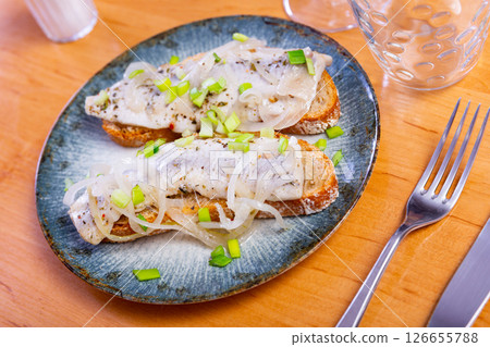 Sandwiches with salted herring fillet, pickled onions and scallions Sandwiches with salted herring fillet, pickled onions and scallions 126655788