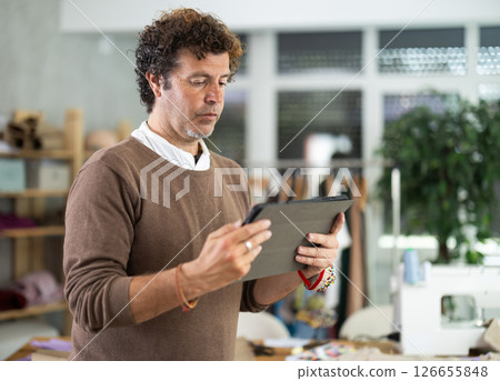 Male fashion designer communicating with client via video call Male fashion designer communicating with client via video call 126655848