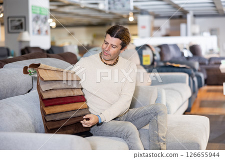 Middle-aged man chooses upholstery color of furniture Middle-aged man chooses upholstery color of furniture 126655944