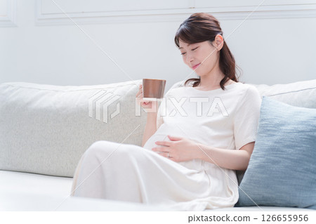 Pregnant woman drinking from a mug Pregnant woman drinking from a mug 126655956