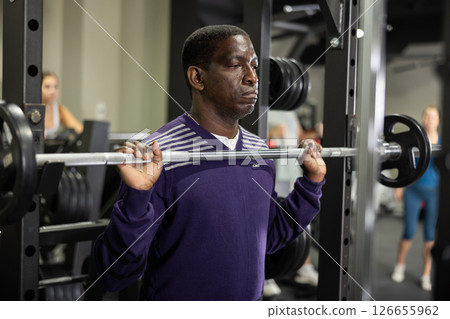 African american man doing barbell squats in gym African american man doing barbell squats in gym 126655962