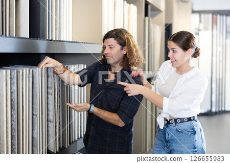 in construction department, male builder with wife choose facing plates for apartment repairs 126655983