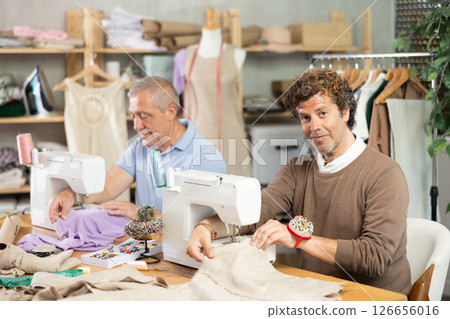 Elderly and adult men tailors sewing on machine 126656016
